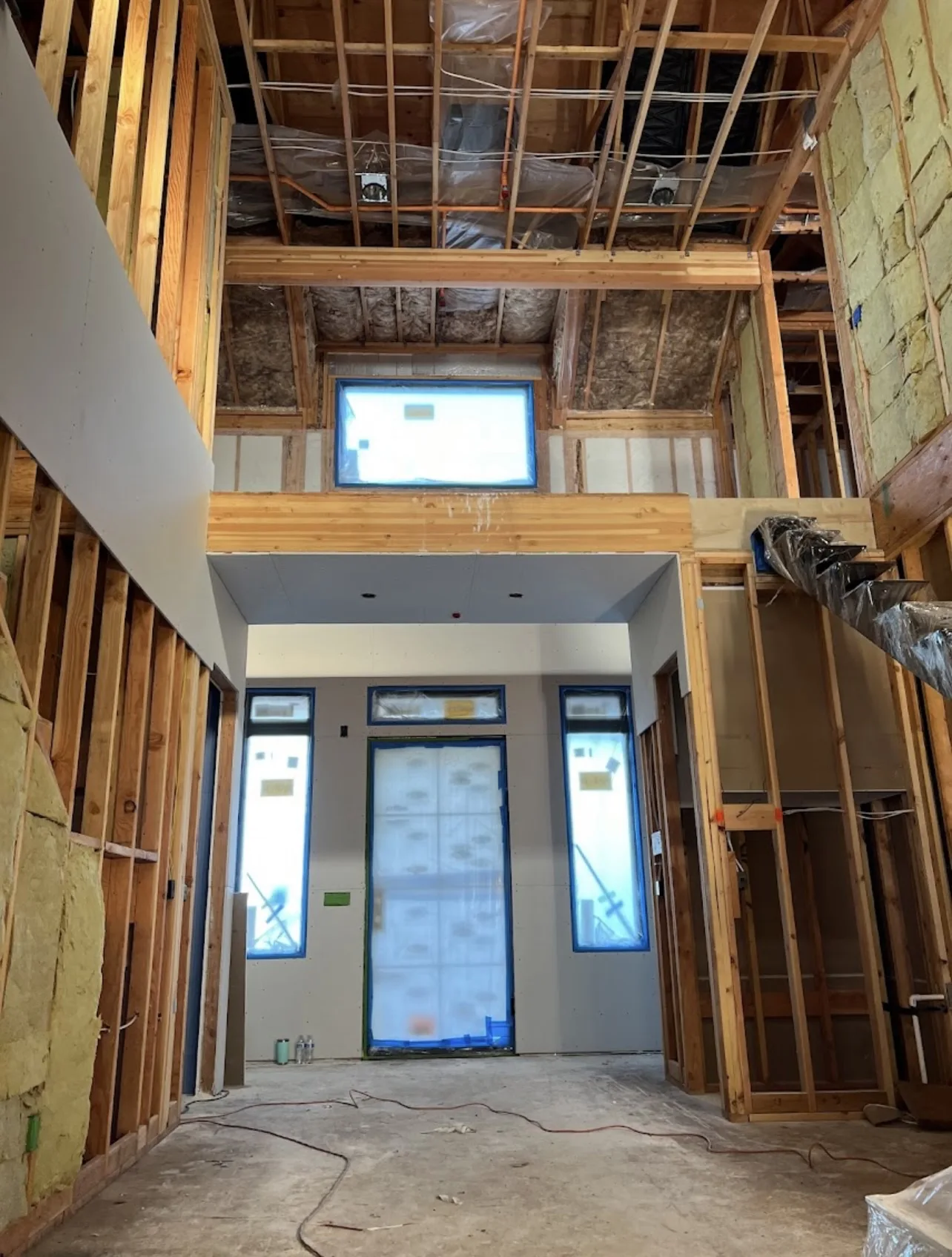 An Altus project in progress with exposed framing and drywall around a tall entry