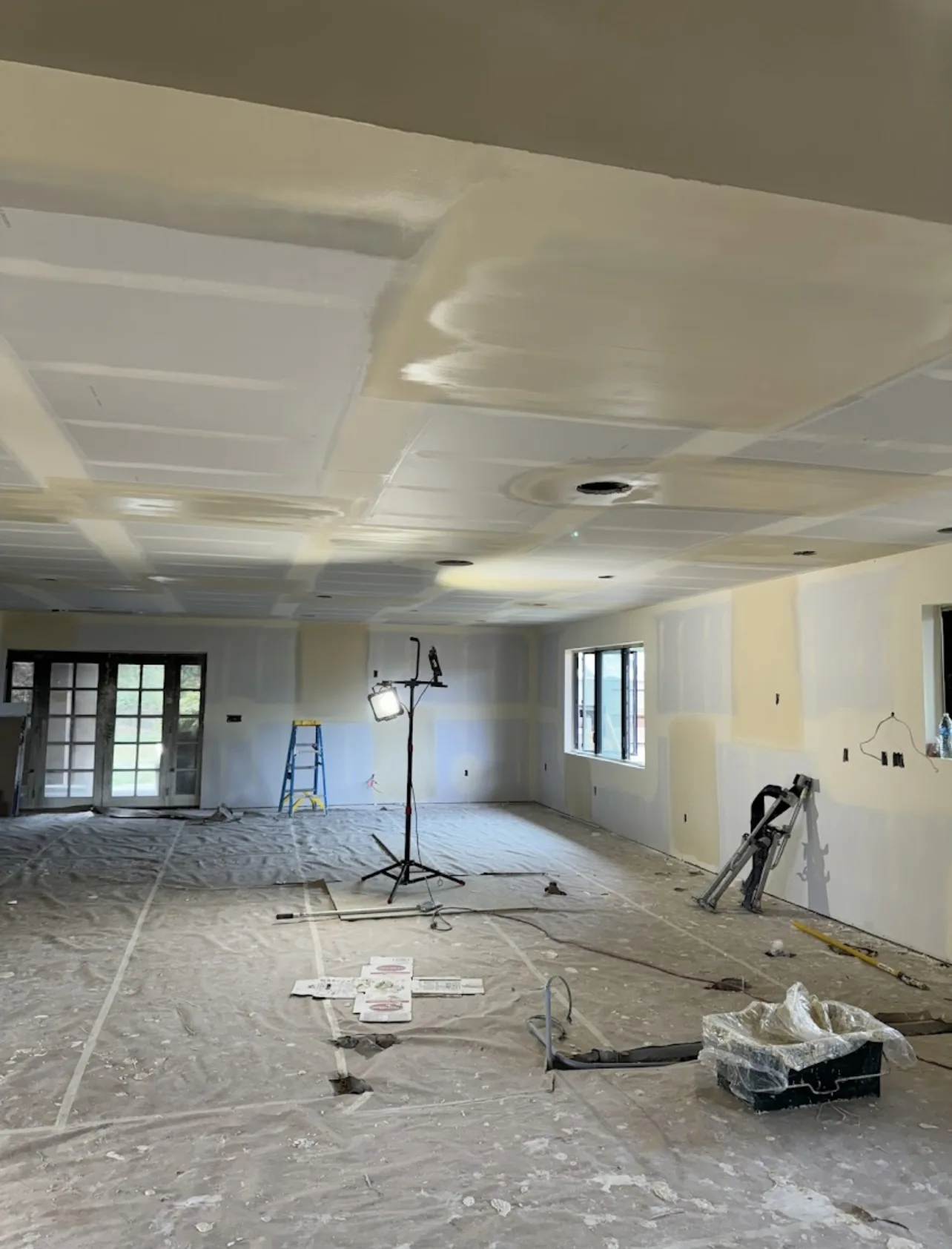 Taped drywall joints across the walls and ceiling of an Altus project in progress
