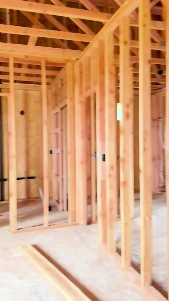 A walk through a new home with exposed framing before drywall installation.