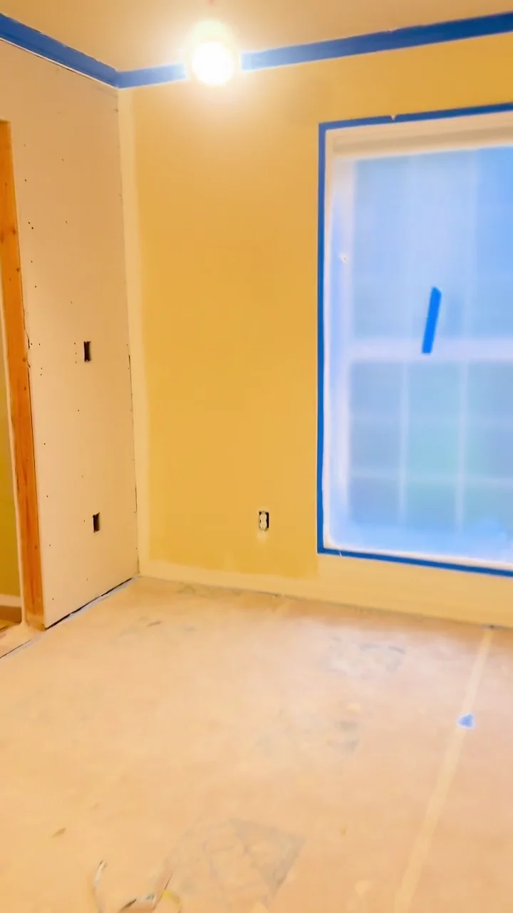 Interior walls, stairs and doorways during a skim-coating project, with floors and windows protected.