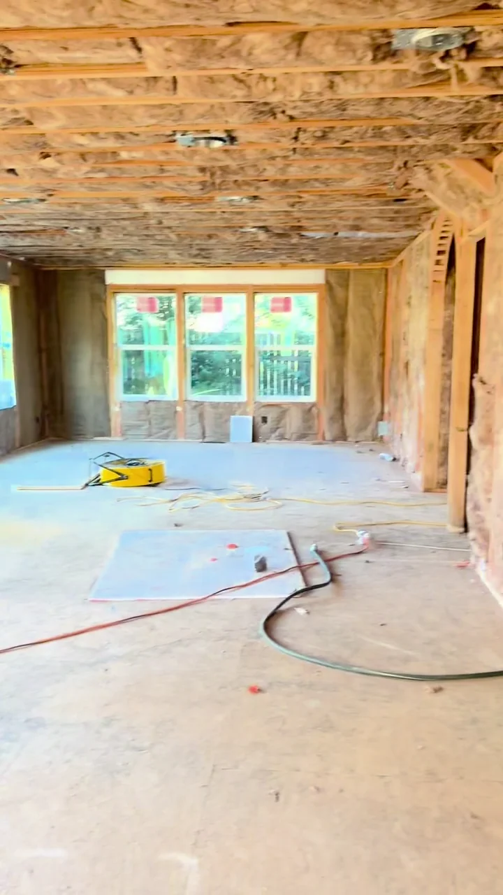 Exposed framing and insulation throughout a home before new wall and ceiling drywall.
