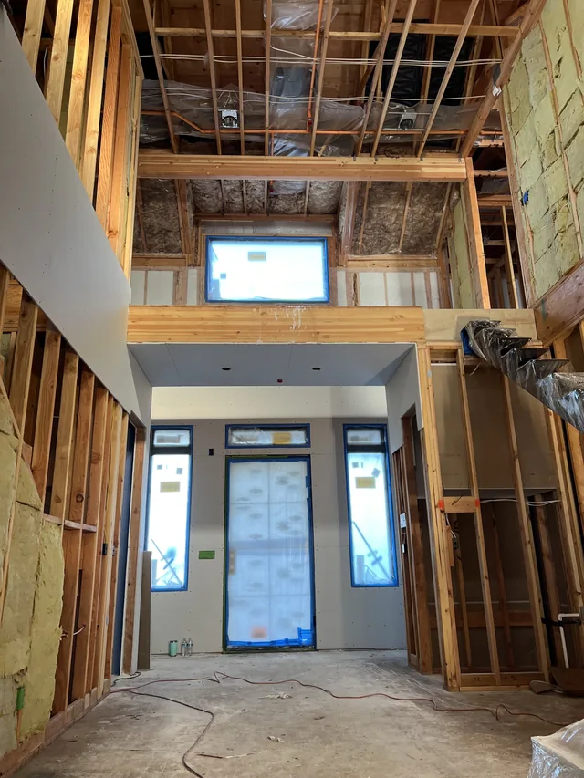 New drywall around the tall entry of an Altus project.