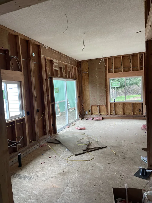 Room under renovation with exposed wall framing and ceiling drywall.
